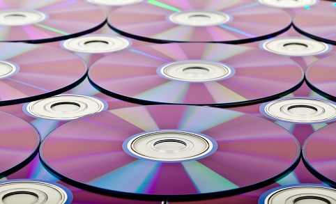 Layered compact disks reflecting various shades forming a generally purple surface