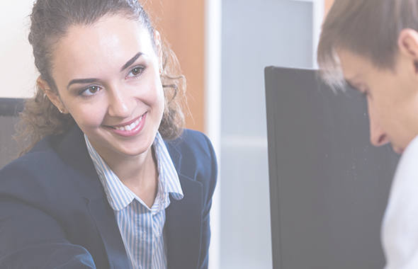 Smiling employee looks at colleague focussing on work item