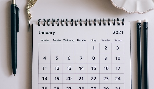 Gold pen and year planner open on a white background