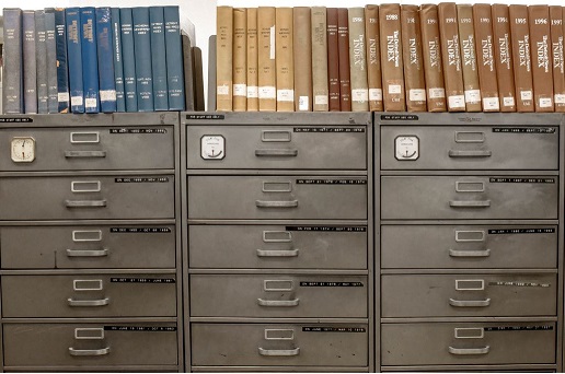 Row of record card cabinets with aged books on top